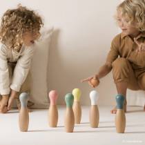 Enfants jouant avec le jeu de quilles Nobodinoz, jouet en bois naturel idéal dès 3 ans pour jouer en famille
