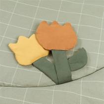 Détails des textures et formes (tulipes, fleurs, arrosoir) sur tapis déveil Nobodinoz