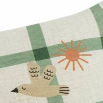 Détail du coussin en lin français Nobodinoz  motif oiseau et soleil sur fond à carreaux verts